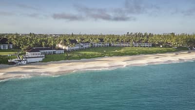 Silhouette of person walking across white sand beach, Four Seasons Resort Ocean Club Bahamas
